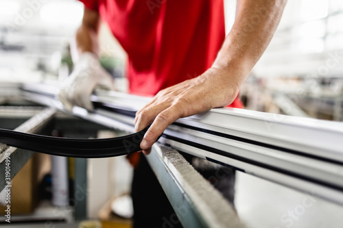 Manual worker assembling PVC doors and windows. Manufacturing jobs. Selective focus. Factory for aluminum and PVC windows and doors production.