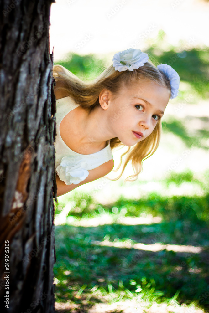Beautiful Girl Looks From The Tree In The Park. Warm sunny day