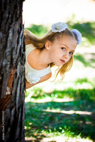 Obraz na płótnie Beautiful Girl Looks From The Tree In The Park. Warm sunny day w salonie