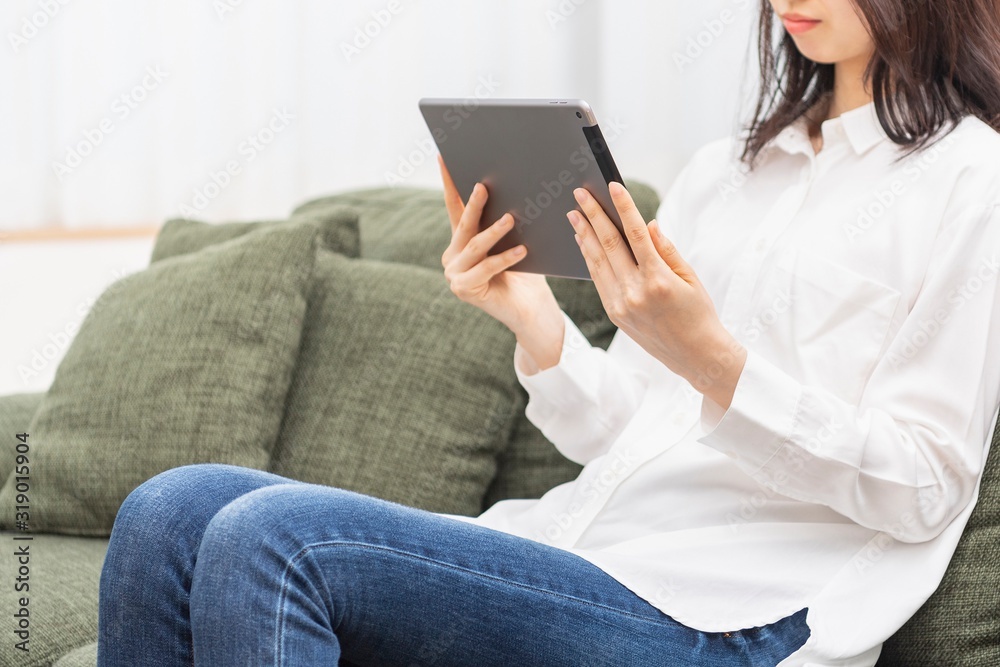 リビングでタブレットを使う女性 リビングでタブレットを使う女性