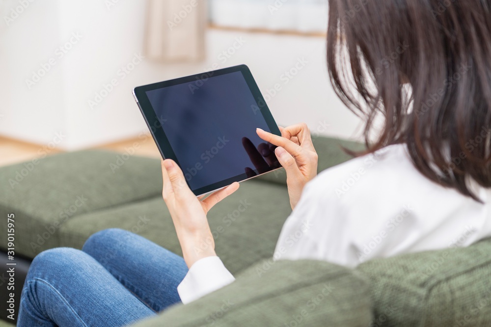 リビングでタブレットを使う女性
