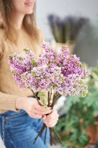 Spring violet lilac flowers, abstract soft floral background. Beautiful bouquet of mixed flowers in womans hands.