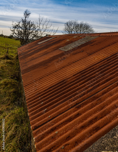 Rusted red corrugated iron roof on an old farm building, Finnis Massford, County Down, Northern Ireland photo