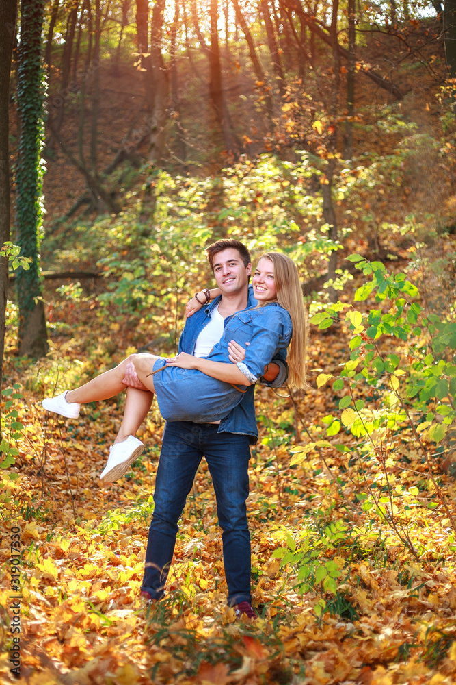 Young happy couple in love together in forest park on sunny day Young happy couple in love together in forest park on sunny day