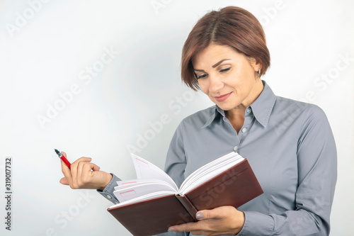 business girl with a red pen and notebook in hands on a white background