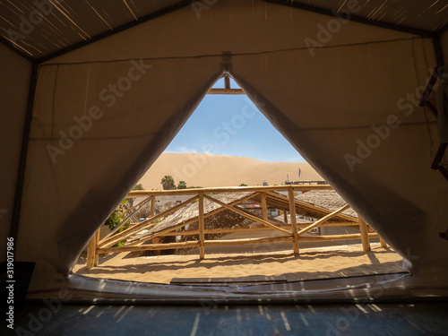 View of desert sand dunes from inside tent at Huacachina oasis Peru