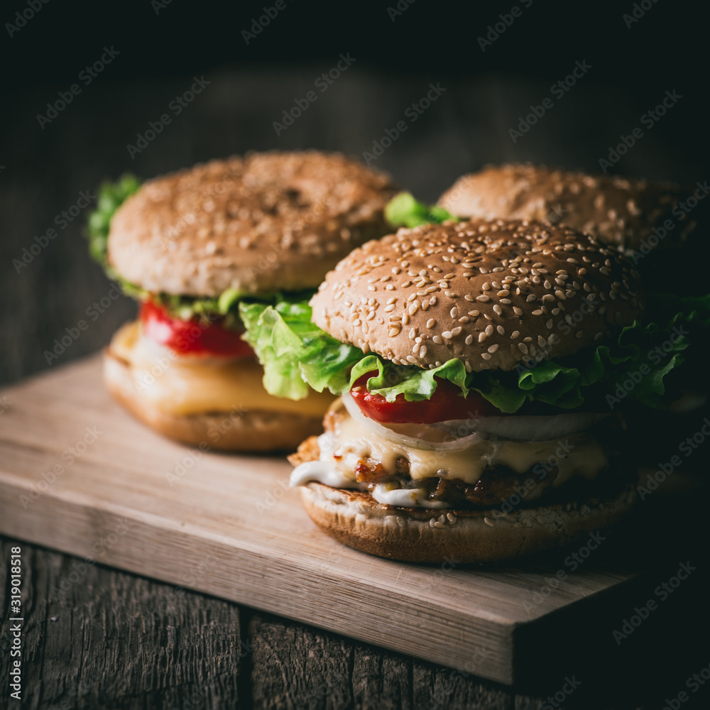 Fresh tasty grilled beef burgers with cheese wood background. Fresh tasty grilled beef burgers with cheese wood background.