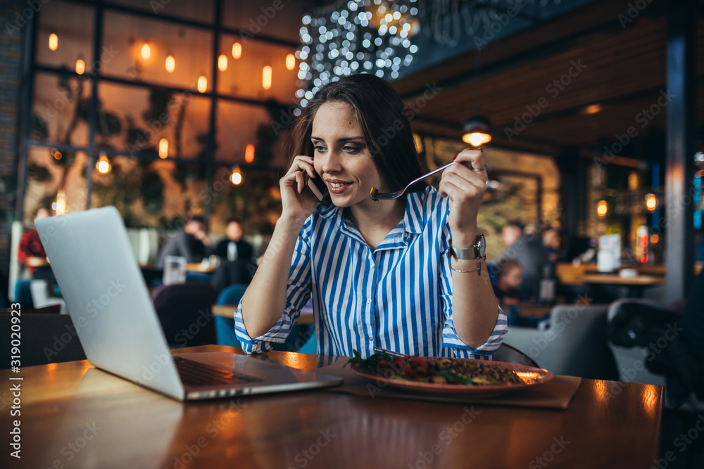 businesswoman having lunch and using laptop in restaurant businesswoman having lunch and using laptop in restaurant