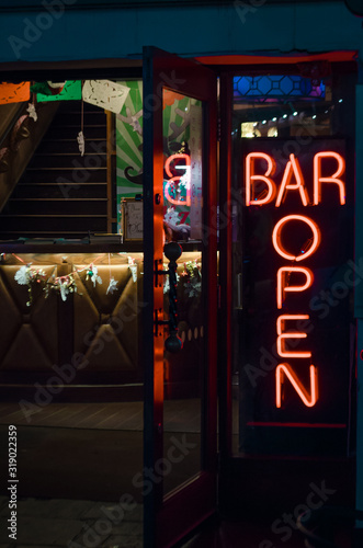 Reflections and neon lights outside a bar announcing that it is open