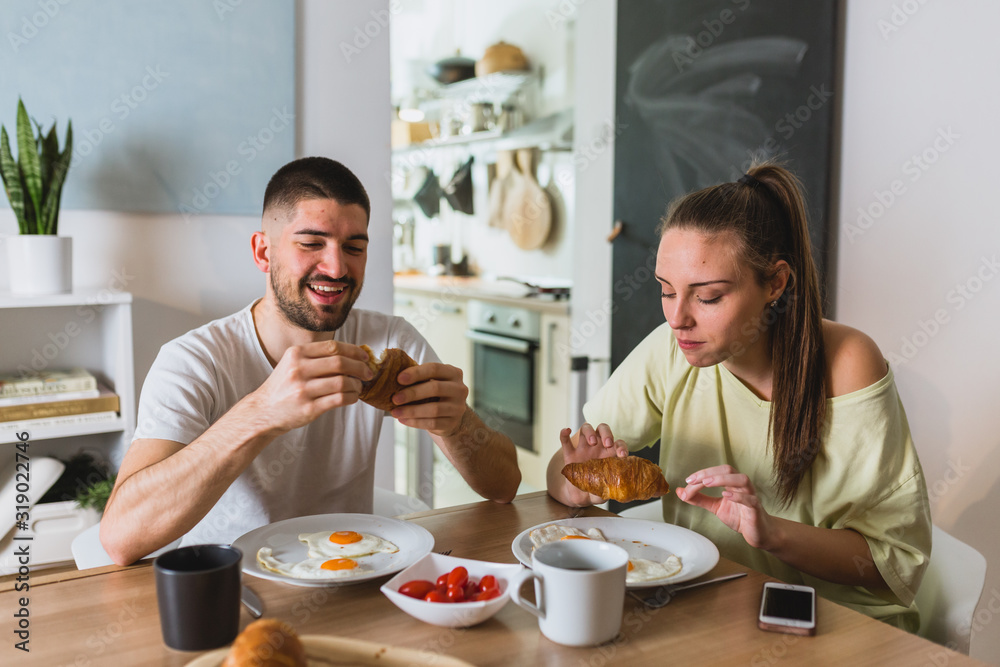 happy romantic couple having breakfast at home
