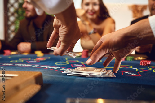 Croupier holds poker cards in his hands at a table in a casino.