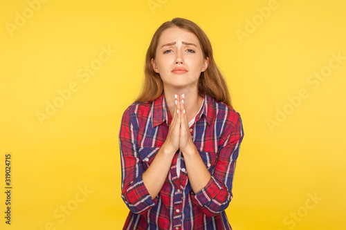 Photos Please, I'm begging! Portrait of desperate ginger girl in shirt keeping arms in prayer gesture and asking forgiveness, feeling sorry for mistake