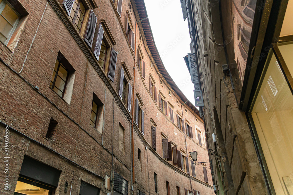 Narrow medieval street in Siena, Tuscany, Italy.