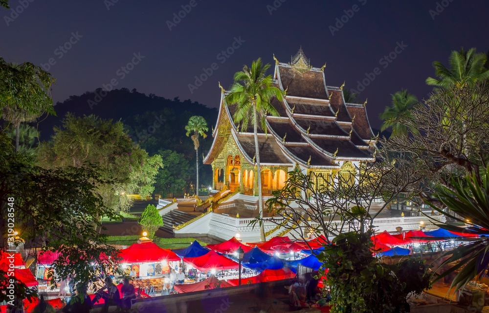 Night market in Luang Prabang, Laos, With illuminated temple and sunset