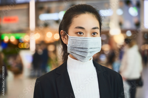 Alarmed female wears medical mask to protect, afraid of infection, in shopping center. Concept individual means protection against biological pollution. Deadly coronavirus in China 2019 2020 2019-nCoV