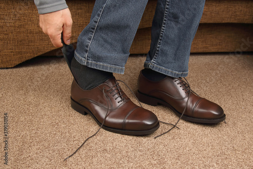 Man tying shoelaces on classic brown shoes