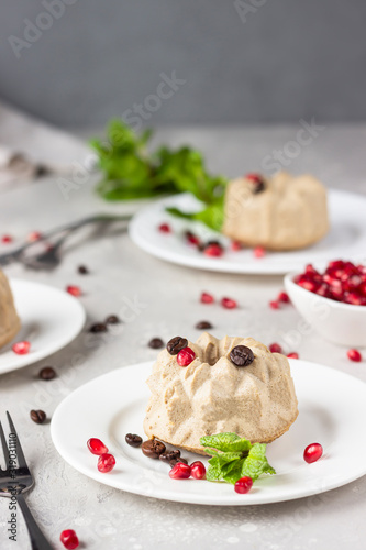 Vegan mini cheesecakes with coffee and banana garnished with coffee beans, pomegranate and mint. No crust coffee cheesecake. 