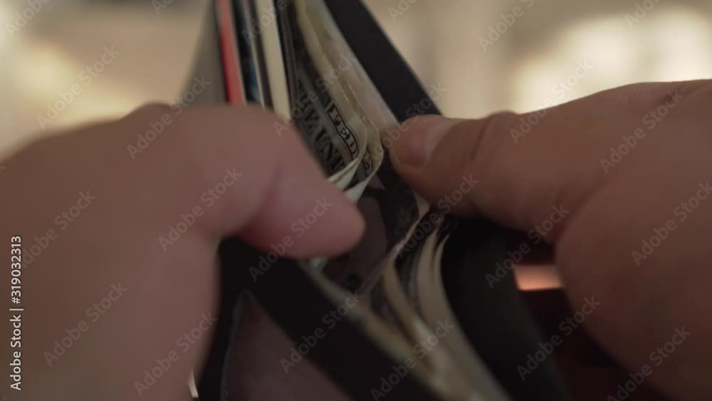 Hands opening a wallet and looking for dollars Hands opening a wallet and looking for dollars