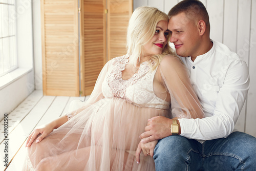 Pregnant woman. Blonde in a long pik dress. Man in a white shirt photo