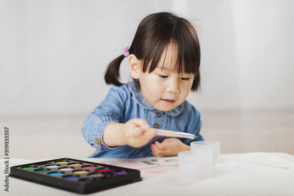 toddler girl practice watercolor paiting at home agianst white background toddler girl practice watercolor paiting at home agianst white background