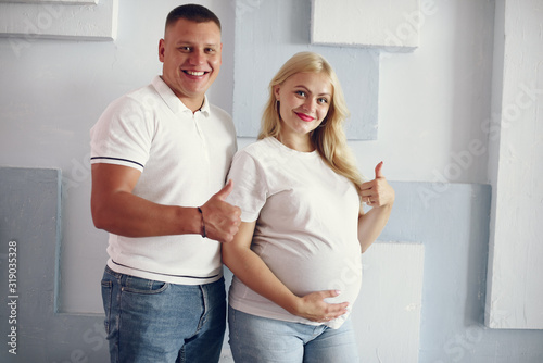 Pregnant woman. Blonde with big belly. Man in a white t-shirt © hetmanstock2