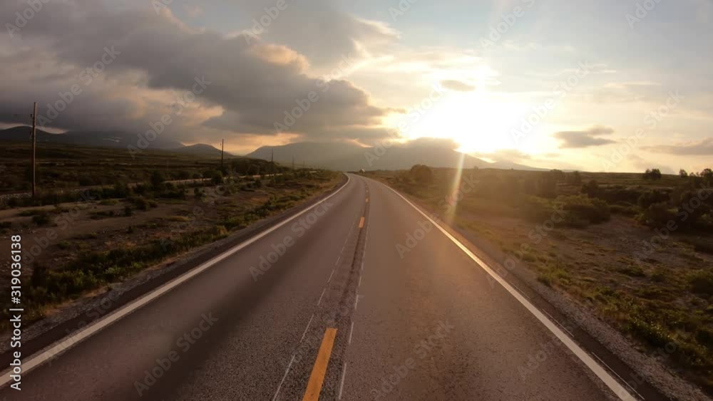 Driving a Car on a Road in Norway at dawn