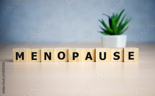 menopause word written on wood block. menopause text on table, concept. photo