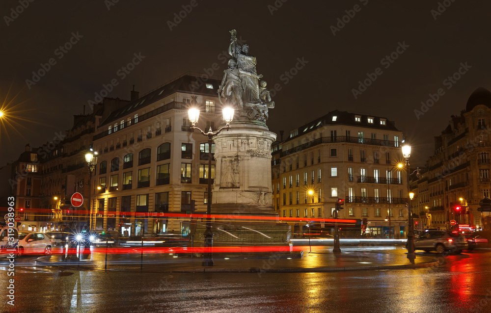 Place de Clichy at rainy night , Paris. Bronze statue of Marechal Moncey at the centre of the square. Crossing four districts of the city at one point.