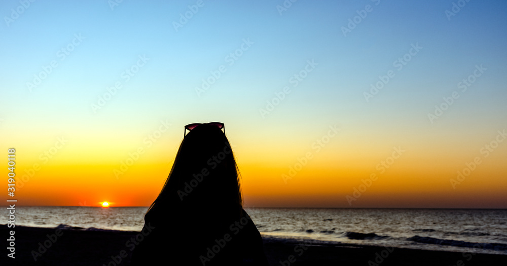 Silhouette of a girl with sunset over Baltic Sea in Lubiatowo, Pomerania, Poland