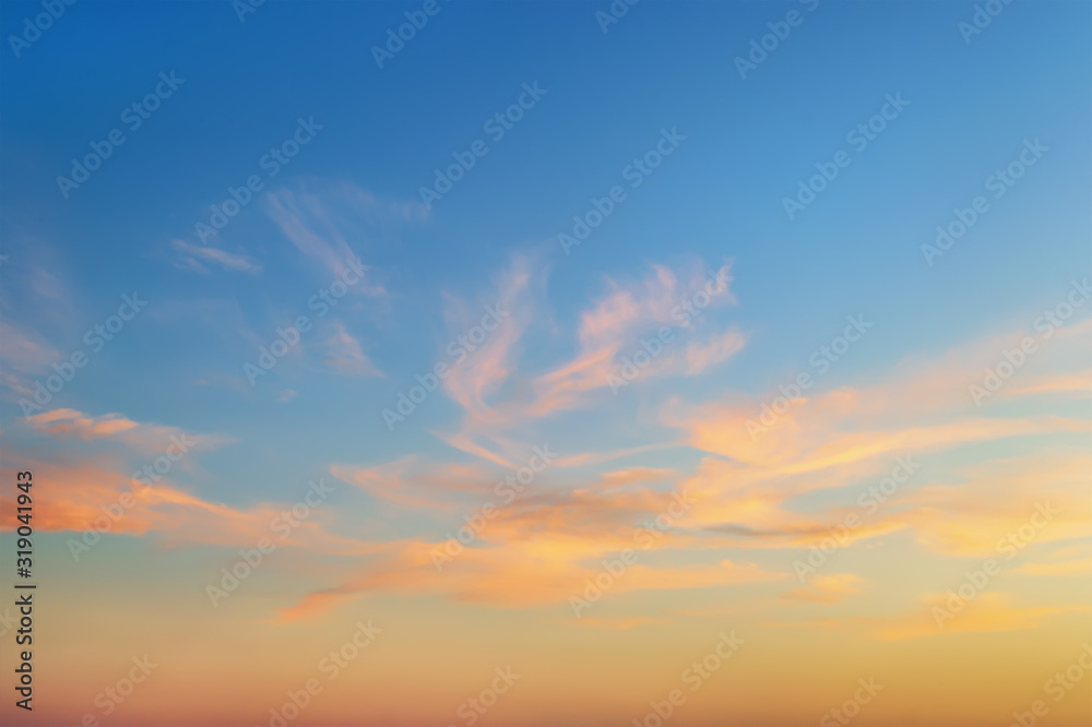 Golden sunset clouds in a clear blue sky. Scenic dusk skyscape. Twilight paradise sky. Calm heaven background.