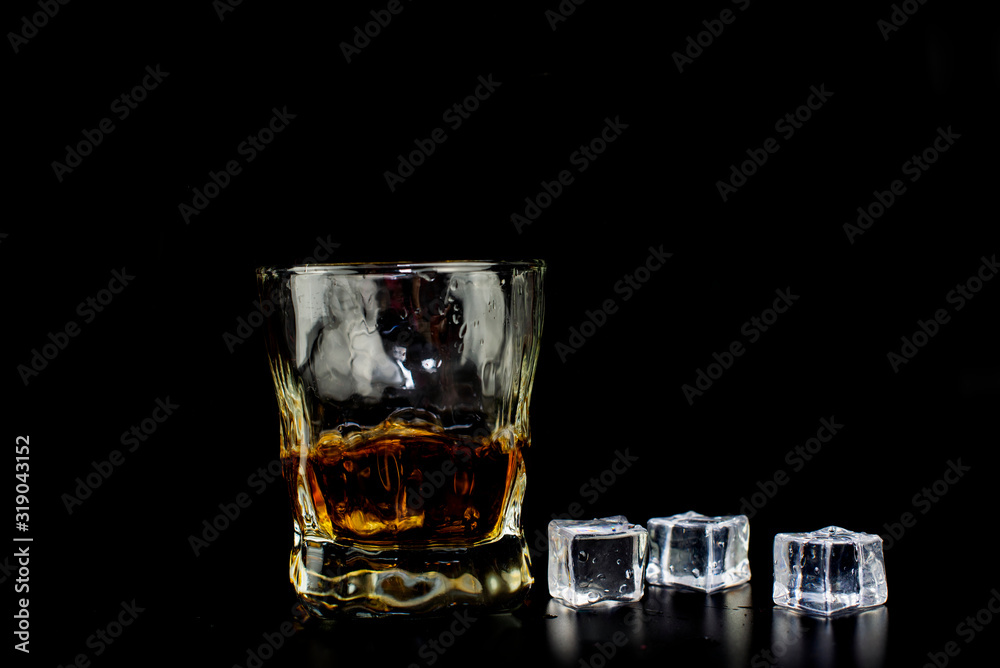 alcohol drink whiskey with ice cubes on a black background alcohol drink whiskey with ice cubes on a black background
