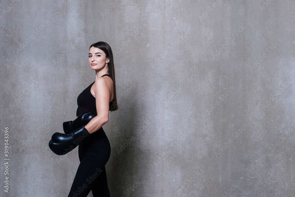Fototapeta premium Image of young sports woman in tracksuit and black putting hands