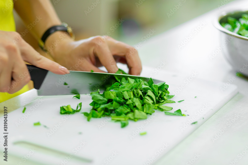 Cook in the kitchen cuts greens a Cook in the kitchen cuts greens a