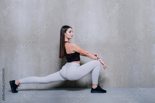 Fitness woman doing lunges exercises for leg muscle workout training. Active girl doing front forward one leg step lunge exercise.