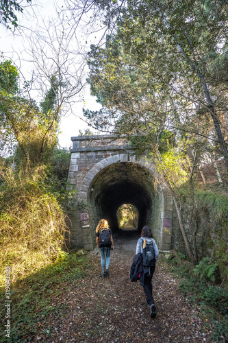 Deba, Gipuzkoa / Spain »; January 26, 2020: Two young people walking towards the tunnel on the coast between Deba and Zumaia