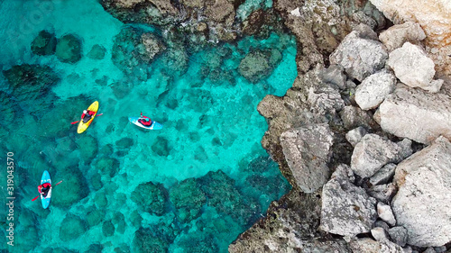 view of a drone from a drone people are kayaking in the sea near the mountains in a cave with turquoise water on the island of Cyprus Ayia Napa photo