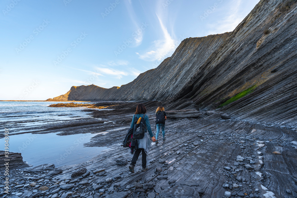 Deba, Gipuzkoa / Spain »; January 26, 2020: Two young people exploring the geopark of the Sakoneta coast one morning