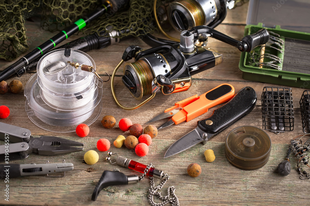 Fishing rods and spinnings in the composition with accessories for fishing on the old background on the table Fishing rods and spinnings in the composition with accessories for fishing on the old background on the table