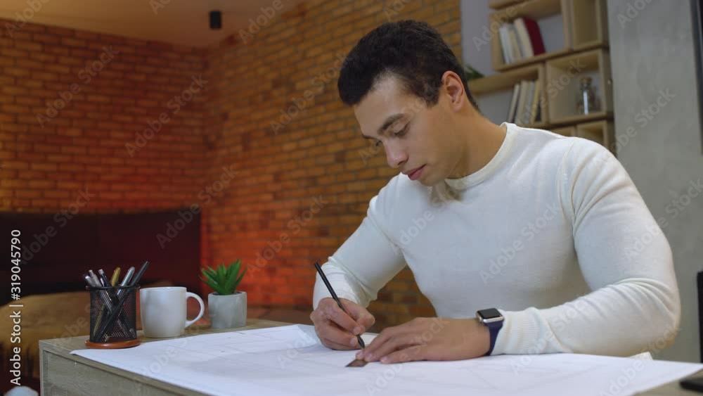 Mixed-race architect drawing by pencil, working on project at home, freelancer Mixed-race architect drawing by pencil, working on project at home, freelancer