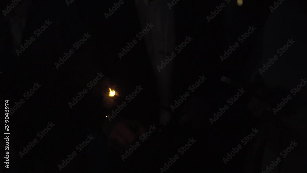 A man lights sparklers for a holiday. A man lights sparklers for a holiday.
