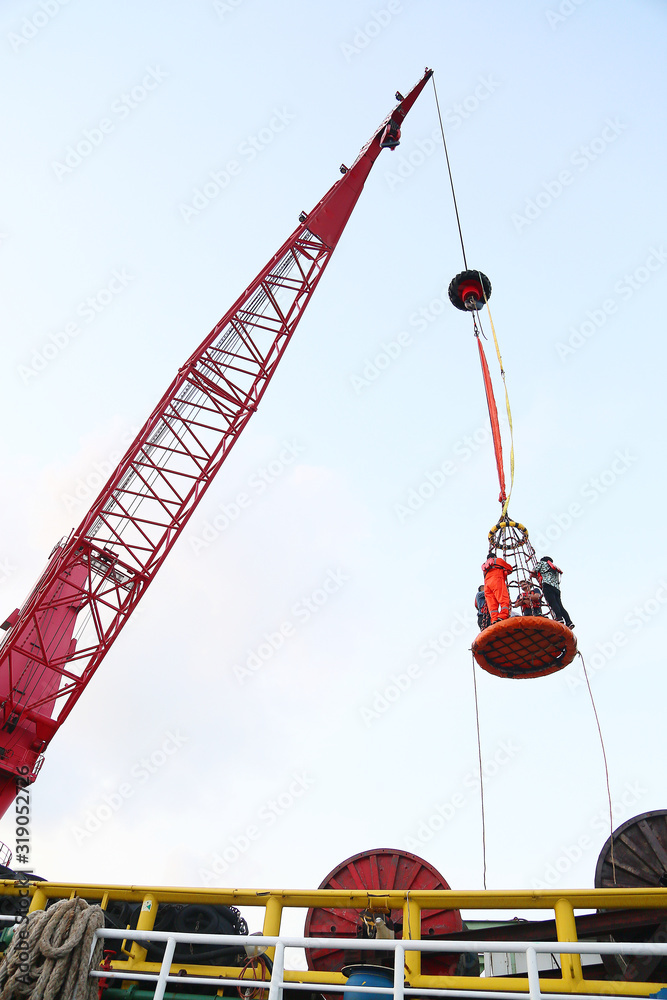 Fototapeta premium The passenger transfer from boat to the construction platform in offshore by personnel basket. The personnel basket is the special tool for transfer the passenger by using crane in the platform.