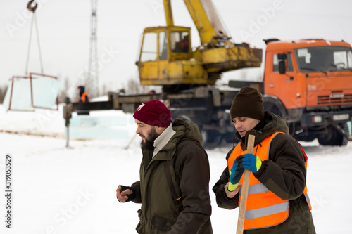 Two workers at the assembly site of the ice town