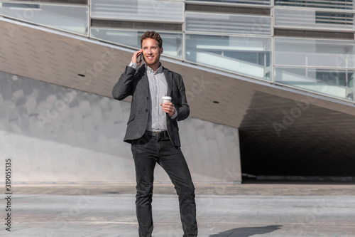 Young business man calling talking on the mobile phone on coffee break from office building outside. Businessman walking on street commute lifestyle.