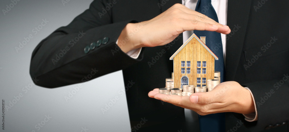 Growing coins house on stack coins in hand. Concept of Investment propert Growing coins house on stack coins in hand. Concept of Investment propert