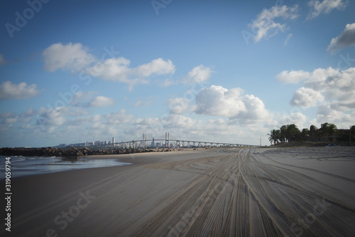 a bridgeview from the beach sand with lots of tiretrail from buggys