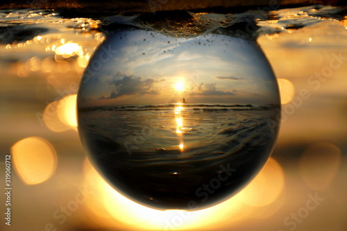 Beautiful sunset captured through a glass lens ball at Cape Henlopen State Park, Lewes, Delaware, U.S.A photo