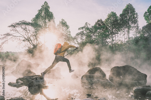 Happy tourists having fun with travel amid morning fog over hot spring at Chae Sorn National Park, Thailand