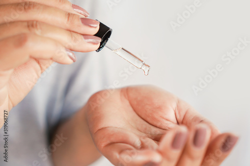closeup woman dropping essential oil on her hand  beauty and spa concept 