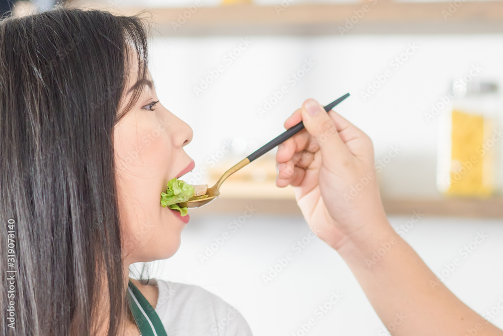 Lovely couple wearing Apron in the kitchen.Cooking vegetable salad.Vegetarian couple show new menu salad in kitchen. Lovely couple wearing Apron in the kitchen.Cooking vegetable salad.Vegetarian couple show new menu salad in kitchen.