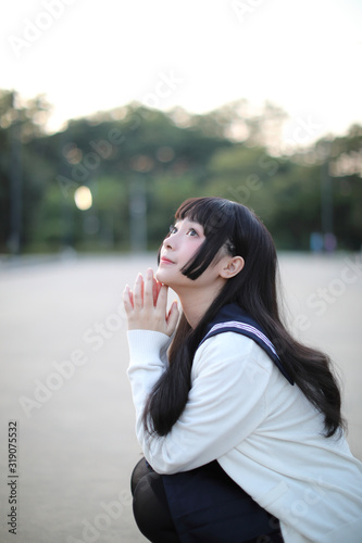 Asian school girl walking in urban city with green darden photo